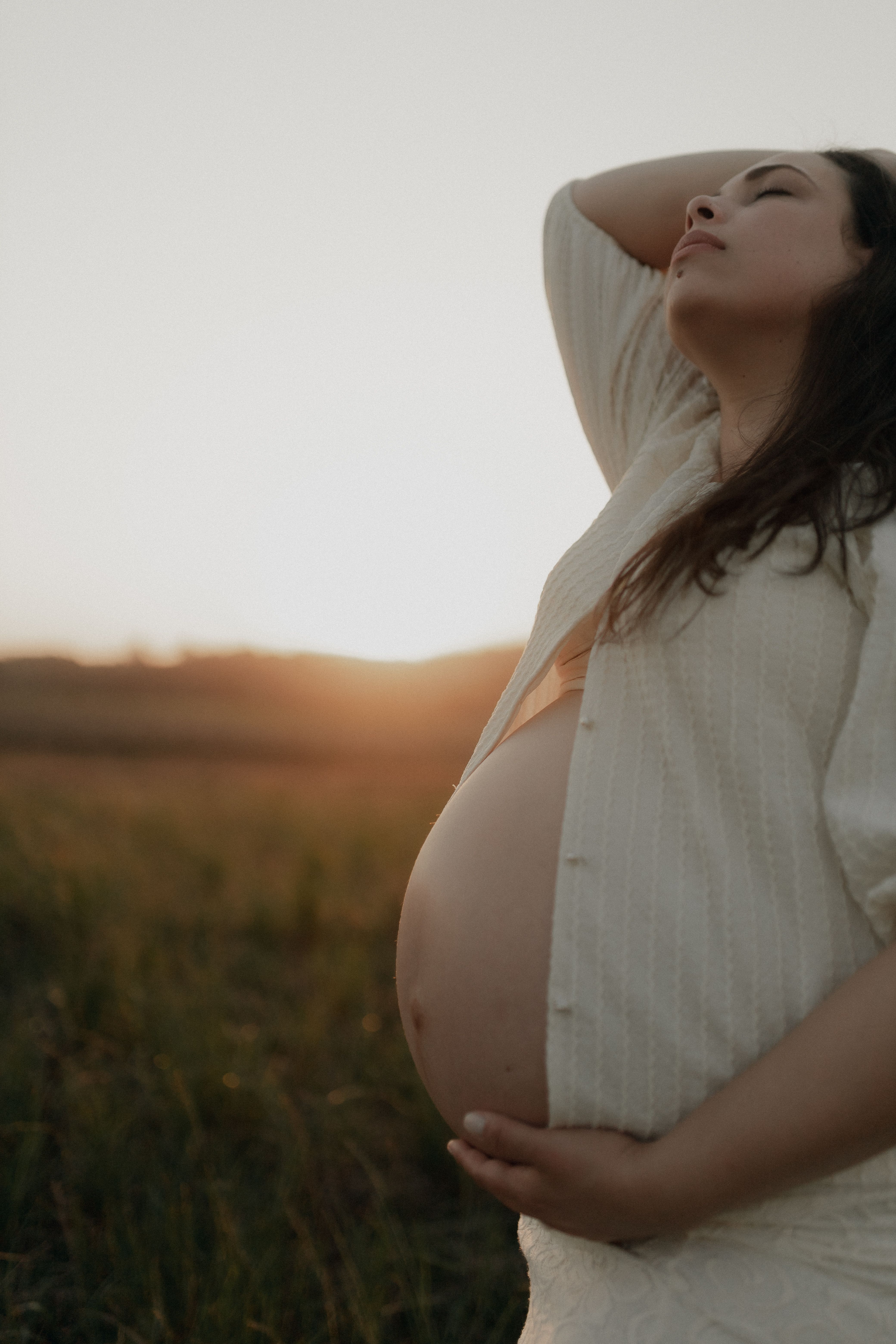 Pregnant woman resting in a sunlit field